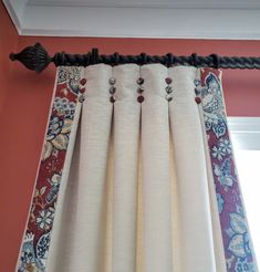 the curtains are hanging on the rod in front of the window with red and blue wallpaper