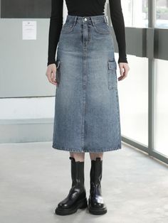 The item pictured is a denim skirt with a midi length and an A-line silhouette. The skirt features utility elements such as large patch pockets on the sides, which add to its practicality. It is designed with a high-waisted fit, judging from the length of the fly and the placement of the waistband. The construction includes a front closure likely consisting of a zipper and button, and the piece shows contrast stitching, which is characteristic of denim clothing.- The side patch pockets are both a functional and stylistic element, emphasizing the skirt's utilitarian design.- The A-line shape offers a flattering fit that may suit a variety of body types, providing comfort and ease of movement.- The midi length and high waist are classic elements that contribute to a timeless appearance, maki Knee-length Denim Skirt With Pockets, Mid-rise Denim Skirt With Pockets For Work, Mid-rise Denim Skirt With Pockets, Mid-rise Fall Skirt With Pockets, Mid-rise Skirt With Pockets For Fall, Fall Mid-rise Skirt With Pockets, Dark Wash Mid-rise Denim Skirt With Pockets, High Waist Utility Skirt With Pockets, Mid-rise Dark Wash Denim Skirt With Pockets