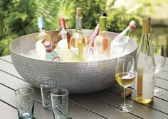 a bowl full of bottles and glasses on a table