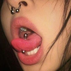 a woman with piercings on her nose and tongue