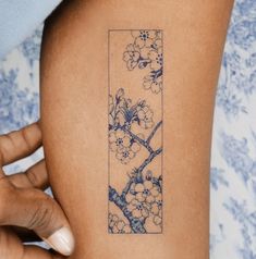 a woman's arm with a tattoo on it that is decorated with flowers and leaves