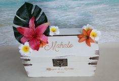 a wooden box with flowers on the beach