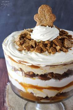 a layered dessert in a glass dish with a cookie on top