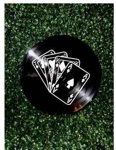 a black record with four playing cards on it