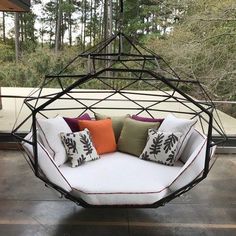 an outdoor swing chair with pillows on it