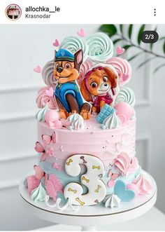 a pink and blue cake with cartoon characters on it