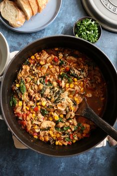 a large pot filled with food next to bread