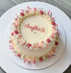 a birthday cake decorated with flowers and the word happy written in frosting on top