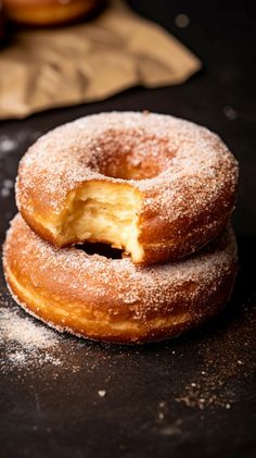 three donuts are stacked on top of each other with powdered sugar around them