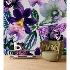 the wallpaper in this room has purple flowers and green leaves on it, along with a wicker chair