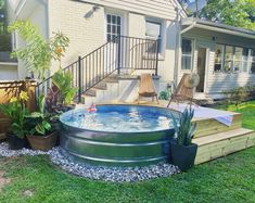 an above ground pool with steps leading up to the deck and patio area in front of a house