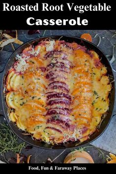 a casserole dish with cheese and vegetables in it on a black plate, surrounded by autumn leaves