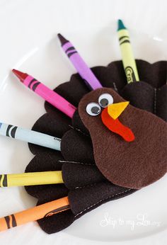 a turkey made out of crayons and colored pencils on a white plate