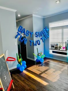 a baby shark birthday party with balloons and streamers in the shape of letters that say it's to be