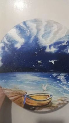 a person holding up a plate with a boat on it and seagulls flying over the water