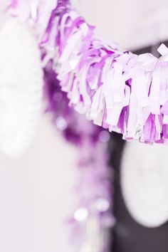 purple and white streamers are hanging from the ceiling in front of a mirror with mirrors behind it