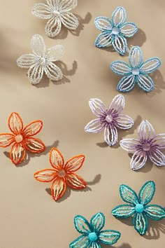 several different colored flowers on a beige surface