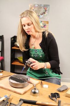 a woman in an apron is working on something with scissors and other items around her