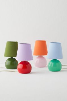 several different colored lamps sitting next to each other on a white surface with one lamp turned off