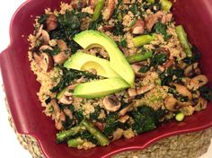 a red bowl filled with rice, vegetables and sliced avocado on top of it