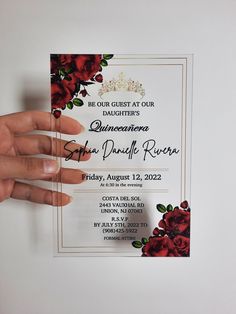 a hand holding up a wedding card with red roses on the front and back side