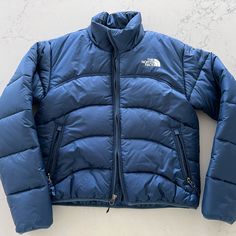 The North Face Short Quilted Puffer Jacket In Water-Repellent And Windproof Ribstop Fabric; Zip Pockets, Elastic Cuffs And Hem. Xs, Navy Blue **Please Note There Are Three Small White Spots On The Bottom Of The Left Sleeve. This Came With The Jacket. The Jacket Was Never Worn But The Tags Are Off.** Great Jacket, Was Too Small For Me Item Number: Nf0a7urf The North Face Jackets Blau, The North Face Puffer Jacket For Hiking, The North Face Winter Travel Outerwear, Functional Blue Outerwear For Travel, Blue Windproof Outerwear For Travel, Blue Puffer Outerwear For Hiking, Short Puffer Jacket, North Face Shorts, Quilted Puffer Jacket