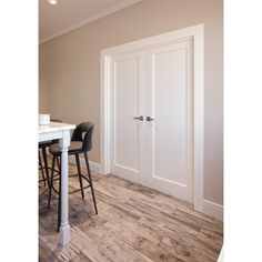 an empty room with two chairs and a table in front of the door that leads to another room