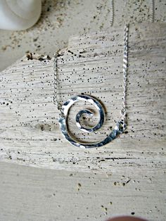 "A tiny Koru necklace made of hand-formed and hand-hammered Sterling Silver ($45-Shown) or 14k Gold-Filled ($55). The Koru is my very favorite symbol. I love it for it's graceful shape (that also resembles a wave), but I love it even more for its symbolism. The Koru (pronounced Koh-Doo) is based on the Maori Koru Fern, as it opens up and unfurls. It represents \"New Life\" or \"New Beginning\". It also stands for \"Circle of Life\" or \"Eternity\", making it a perfect gift between family or frie Modern Twist Swirl Jewelry As Gift, Minimalist Spiral Hand Forged Jewelry, Modern Twist Swirl Jewelry For Gift, Modern Twist Handmade Jewelry For Gift, Sterling Silver Swirl Jewelry As A Gift, Sterling Silver Swirl Jewelry Gift, Handmade Jewelry With A Modern Twist As A Gift, Handmade Jewelry With A Modern Twist For Gifts, Nickel-free Sterling Silver Swirl Necklace