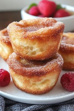 three donuts stacked on top of each other with raspberries in the background