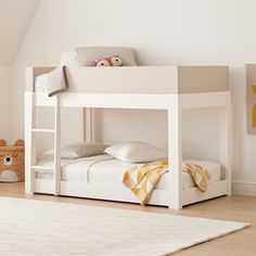 a white bunk bed sitting in a bedroom next to a stuffed animal on the floor