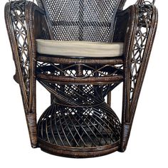 the wicker chair has a cushion on it's backrest and seat pad