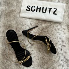 Black And Gold Schutz Heels. The Black Heel Has A Shimmer To It. 4 Inch Heel.Strap Wraps Around The Ankle And Buckles. Schutz Shoes Run A Half Size Smaller (This Fits 8.5). Never Worn. Nude Strappy Heels, Metallic Pumps, Strappy Block Heels, Ankle Sandals, Caged Heels, Peep Toe Shoes, Black Heel, Strappy Sandals Heels, Stiletto Sandals