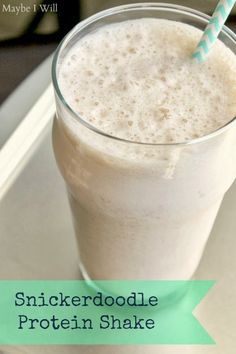 a smoothie in a glass with a blue and white straw sticking out of it