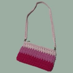 a crocheted purse with pink and white stripes on the front, hanging from a string