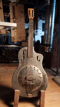 an old guitar sitting on top of a wooden table