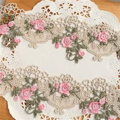 an embroidered doily with pink roses on it