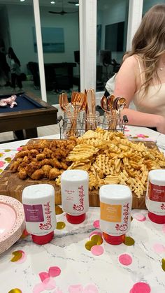 a table topped with lots of different types of food next to cups and sauces