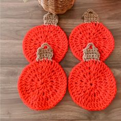 three crocheted ornaments sitting on top of a wooden table next to a basket