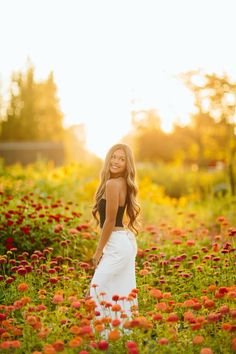 a woman standing in a field of flowers