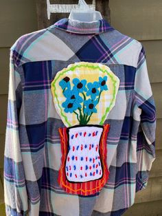 This is a one-of-a-kind comfy flannel shirt is adorned with a festival of flowers! The shirt it's self has been rescued, and given a second chance!  Each flower patch was handcrafted, then placed into organized randomness and sewn on.  Of course, the design is  by me on my super-duper-sewing machine in my cozy studio in Fickling Mill, Ga, USA Here are the deets; Chest; 22 inches Length from back of collar; 28 inches Sleeve length from underarm; 18 inches Blue Bohemian Shirt For Fall, Bohemian Blue Shirt For Fall, Hippie Long Sleeve Cotton Shirt, Fall Festival Cotton Shirt, Bohemian Cotton Shirt For Fall, Cotton Festival Shirt For Fall, Spring Plaid Flannel Shirt, Plaid Flannel Shirt For Spring, Blue Cotton Flannel Shirt For Spring