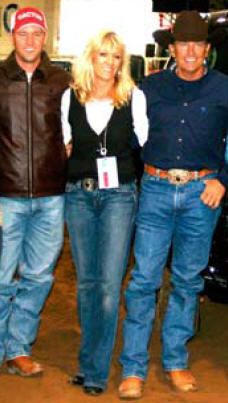 two men and a woman standing next to each other in front of a car dealership