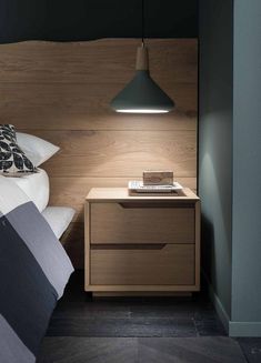 a bed with a wooden headboard and night stand next to it in a bedroom