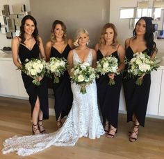 the bridesmaids are all dressed in black dresses and holding their bridal bouquets