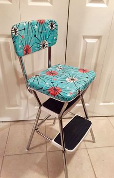 a blue and red chair sitting on top of a tiled floor next to a white door