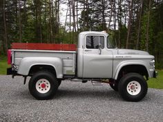 a silver truck parked on top of a gravel road