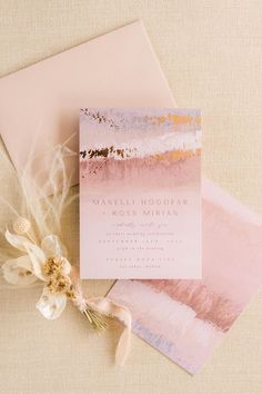 the wedding stationery is displayed on top of an envelope