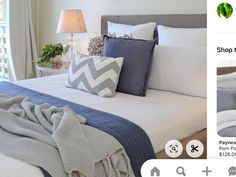 an image of a bed with white sheets and blue pillows on the bottom right hand corner