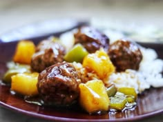 meatballs and pineapples are served over rice on a brown plate with a spoon