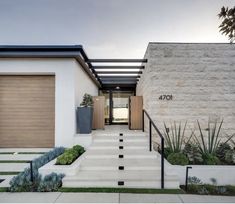 a modern house with stairs leading up to the front door