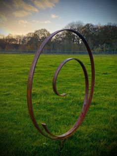 a metal sculpture in the middle of a grassy field